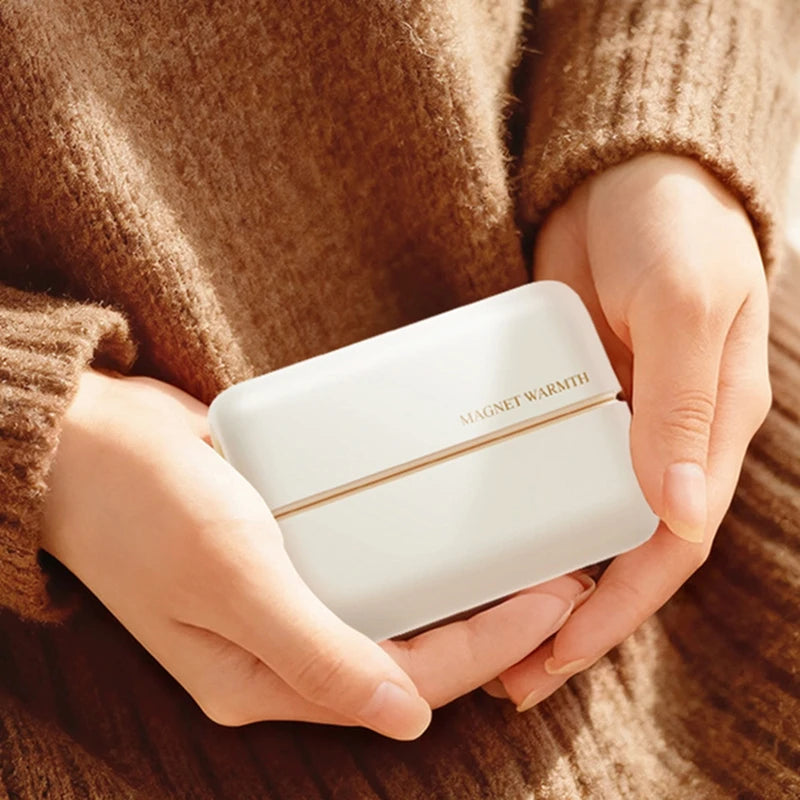 Magnetic hand warmer held in hands for warmth